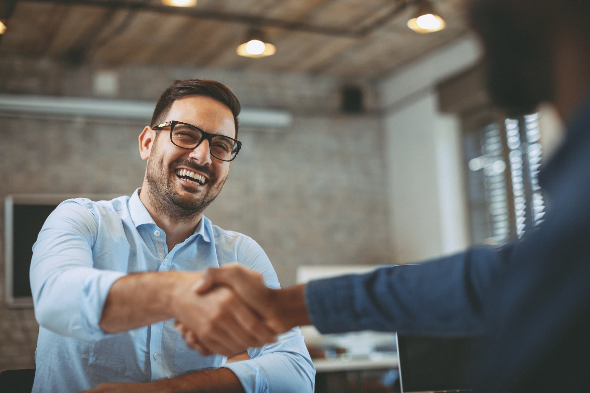 man shaking hand to show value of collaboration when creating a data management strategy